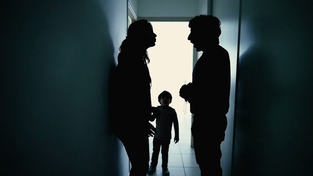 parents arguing in hallway with child in