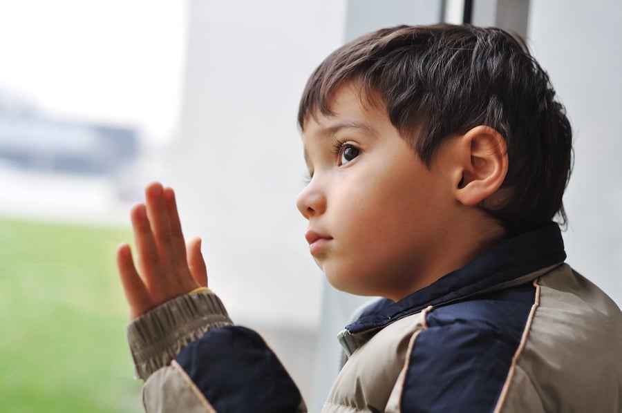 young child looking out window