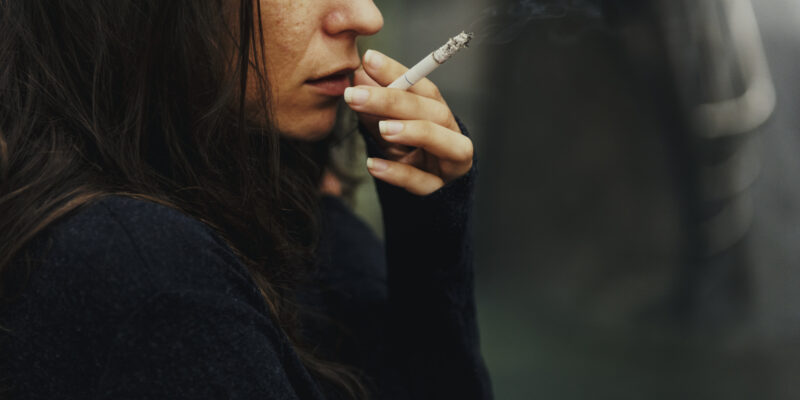 a stress woman resorting to smoking to calm herself