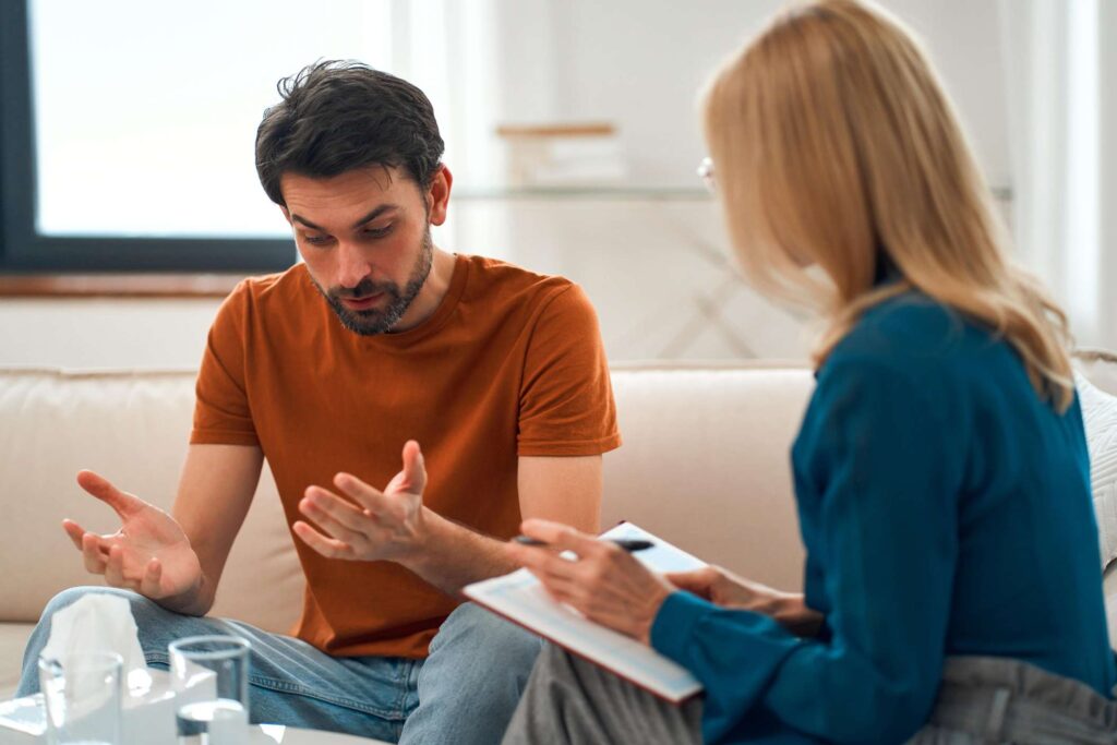 man in depression sitting beside his psychotherapist