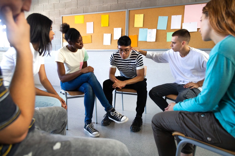 group of teens speaking in support group