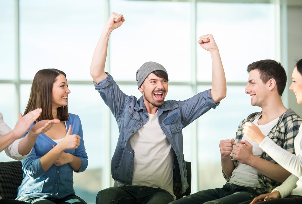 man who had let go of his trauma being applauded by members of his group therapy