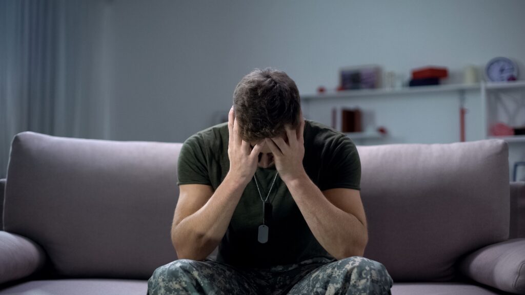 Nervous male military suffering PTSD, sitting alone at home