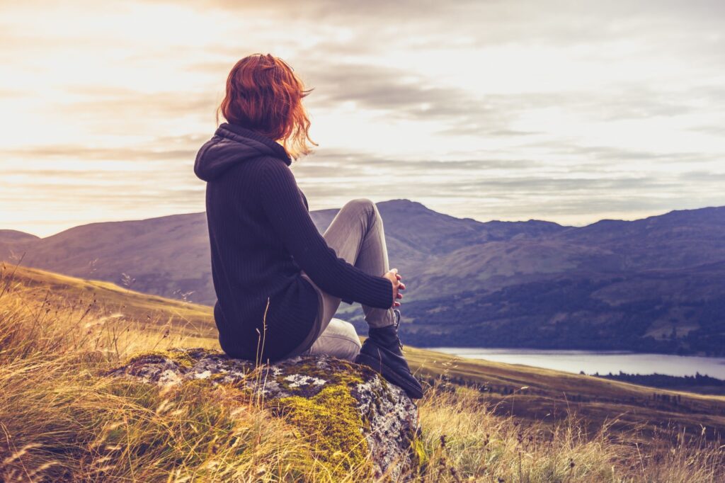 woman in an outdoor looking scenic view recalling and treating trauma with self healing process