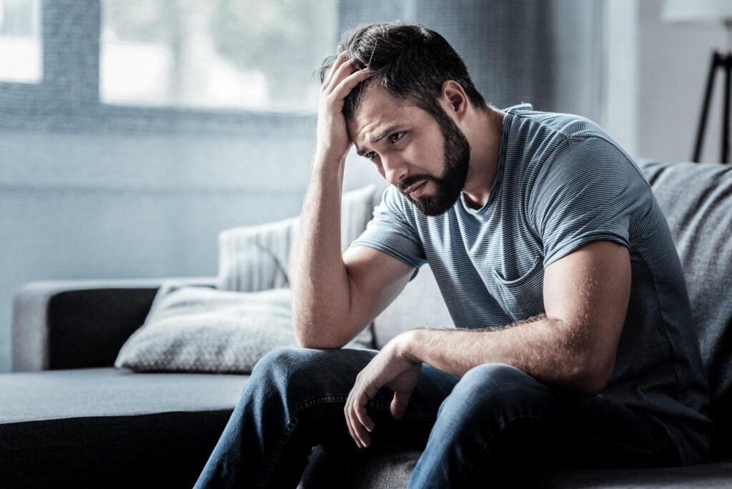 man sitting on the sofa and in depression