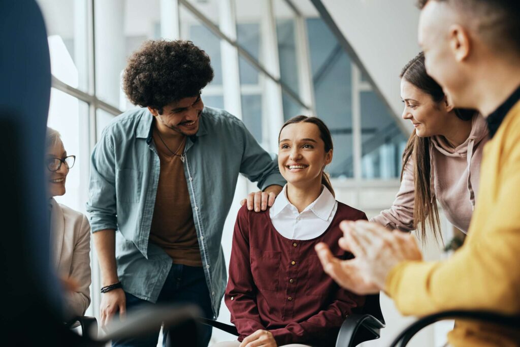 young happy woman receives support from attenders of group therapy at mental health center