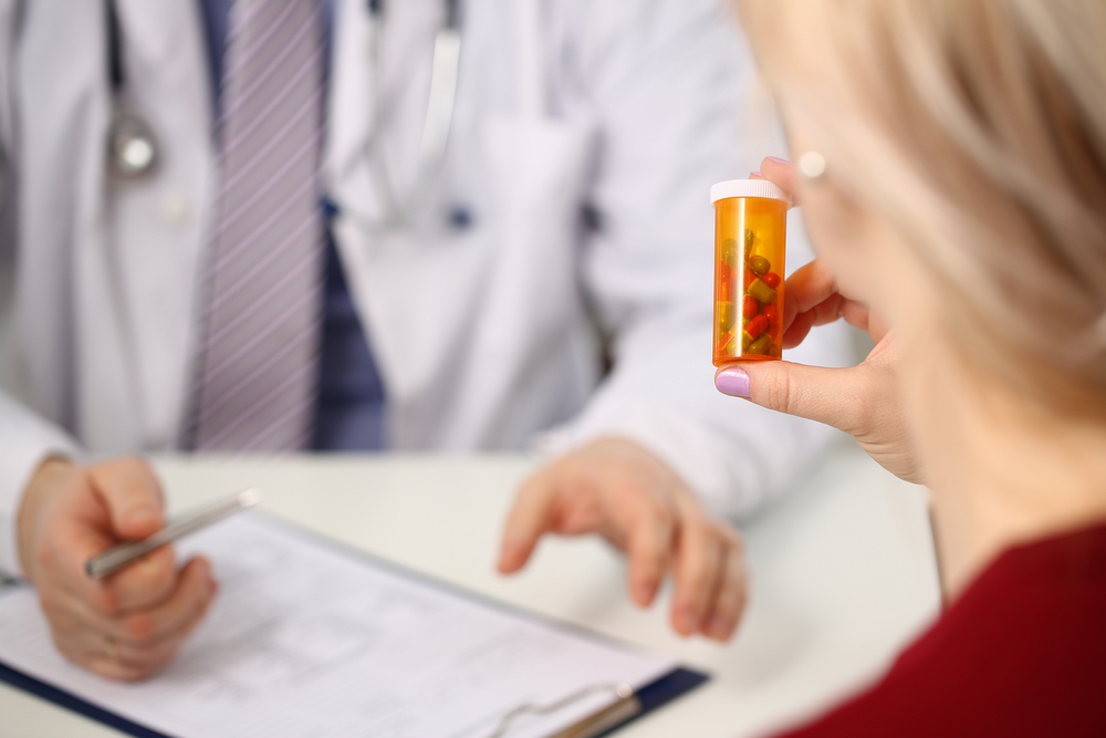 Doctor prescribing medicine to woman in clinic