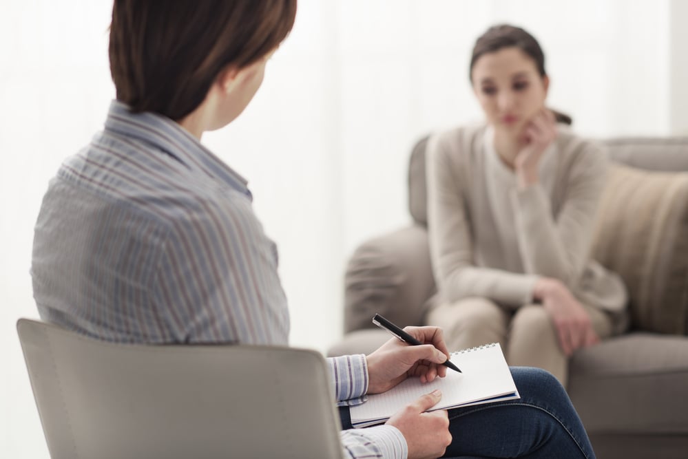 therapist explaining PTSD vs Adjustment Disorder to her patient