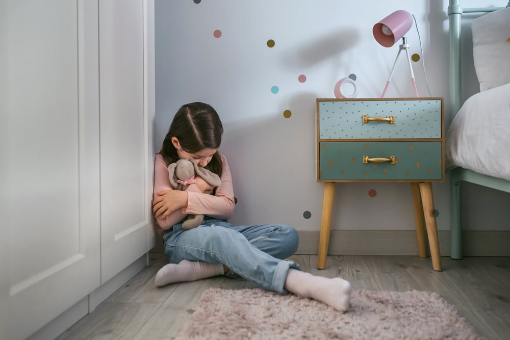 a child who experienced trauma sitting along in a room