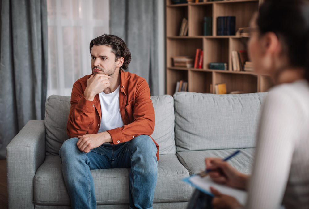 A man reflecting during a conversation with a therapist in addiction therapy