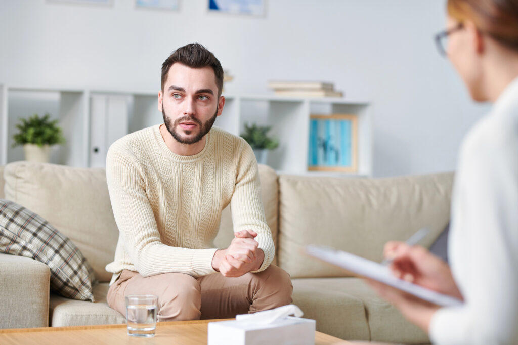 man in treatment session listening to a therapist on how to avoid seizures caused by PTSD