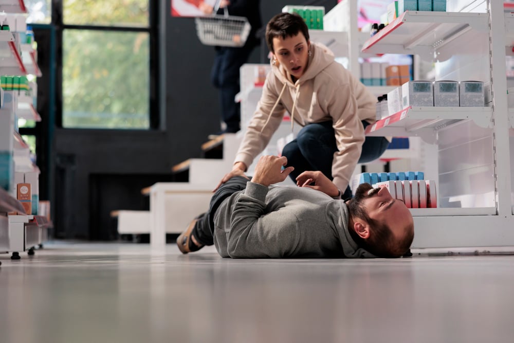 woman running to man having seizure in medical store