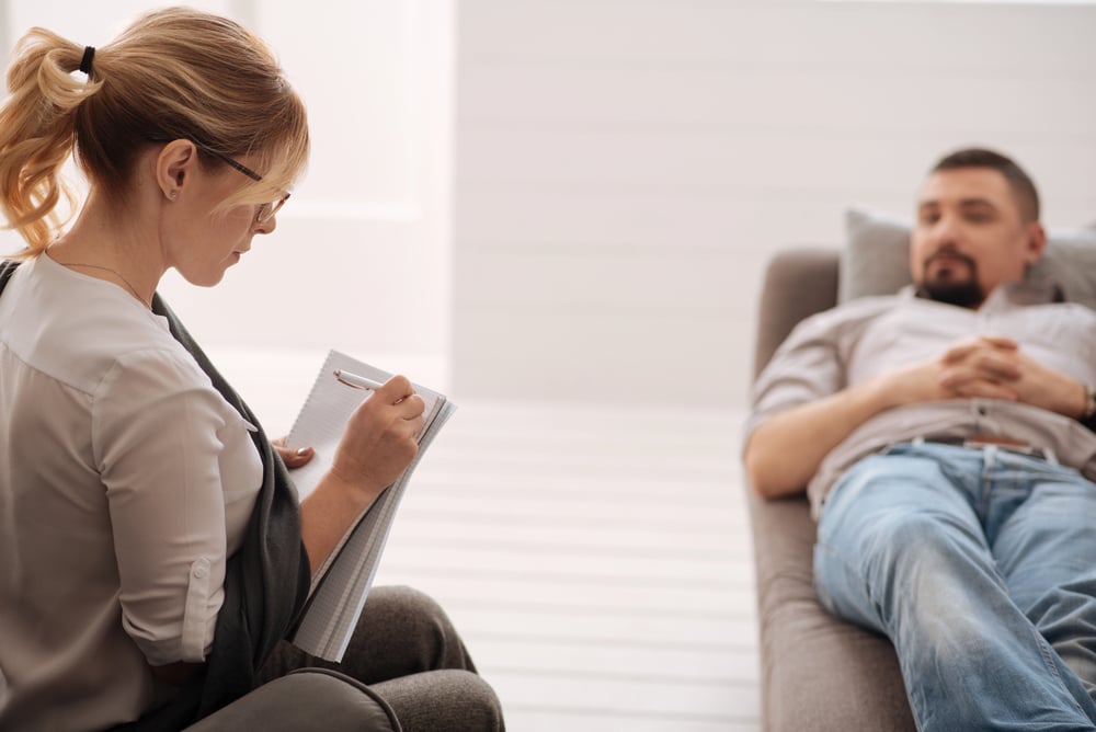 A man lying on a couch during a professional trauma therapy session