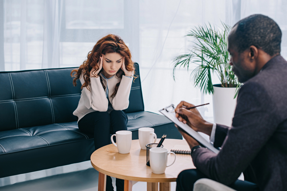 woman discussing her addiction and mental health issues with a counselor during therapy