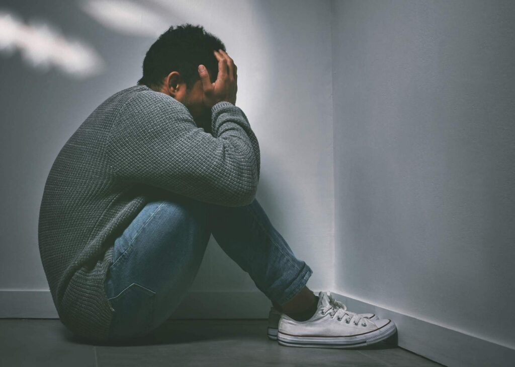 man sitting on the floor with signs of depression and trauma