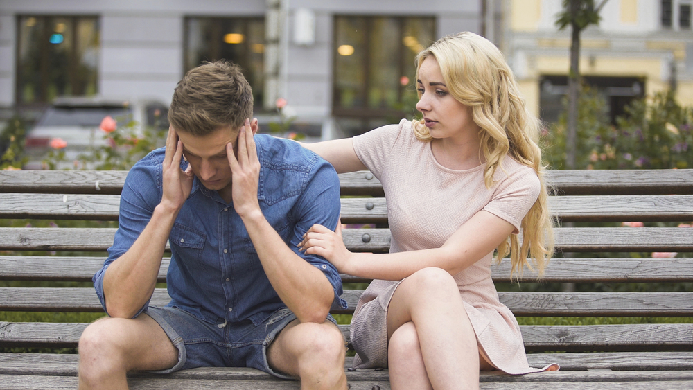 young couple sitting on the bench outdoor