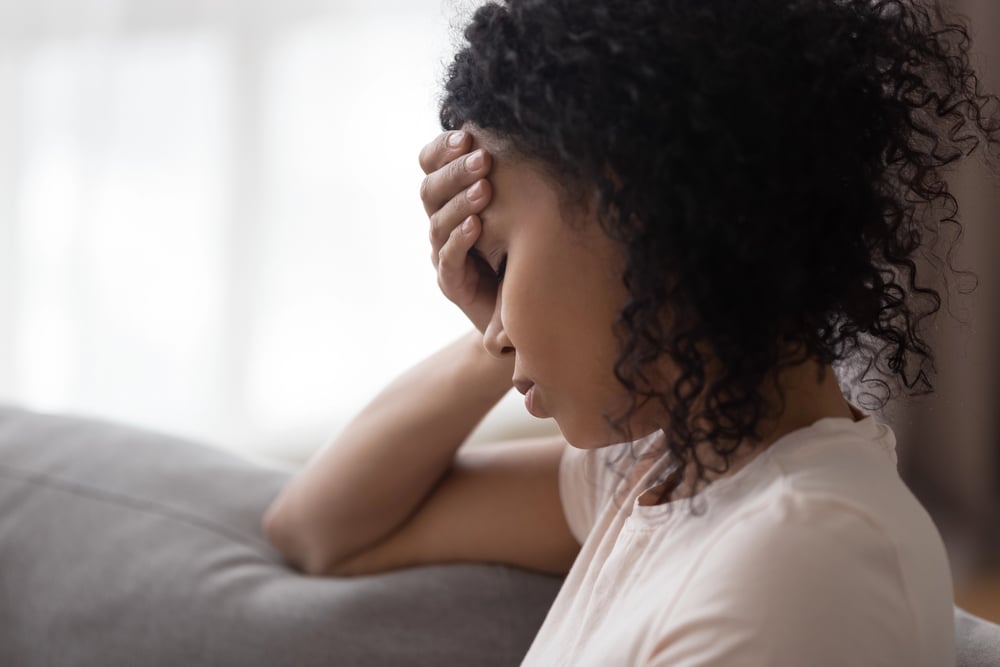 a woman sitting on sofa suffering from past trauma