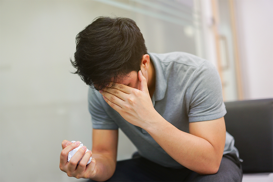 person covering their face feeling stressed