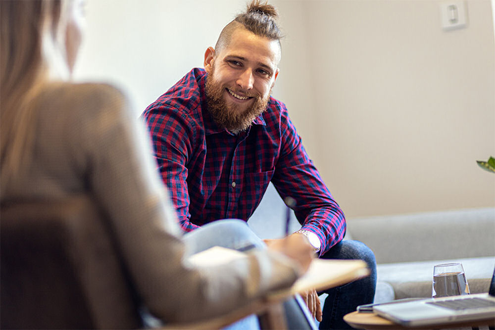 man smiling sitting down in therapy