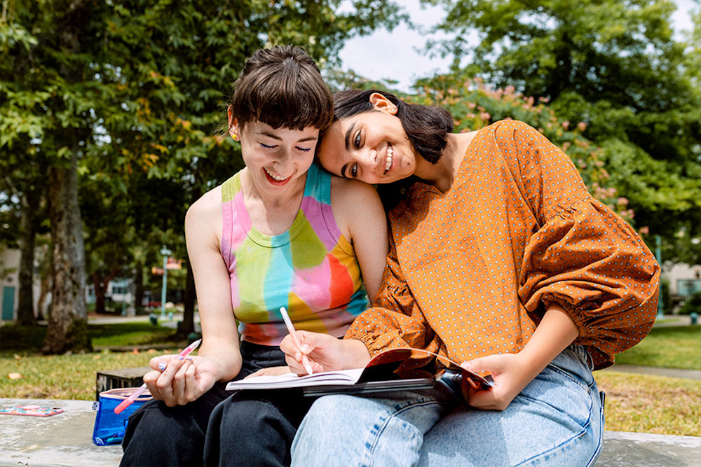 two women sitting together and smiling