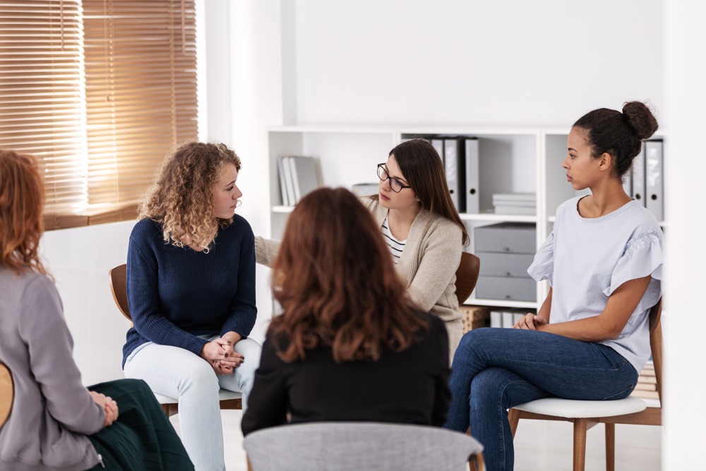 group of people sitting in circle during therapy